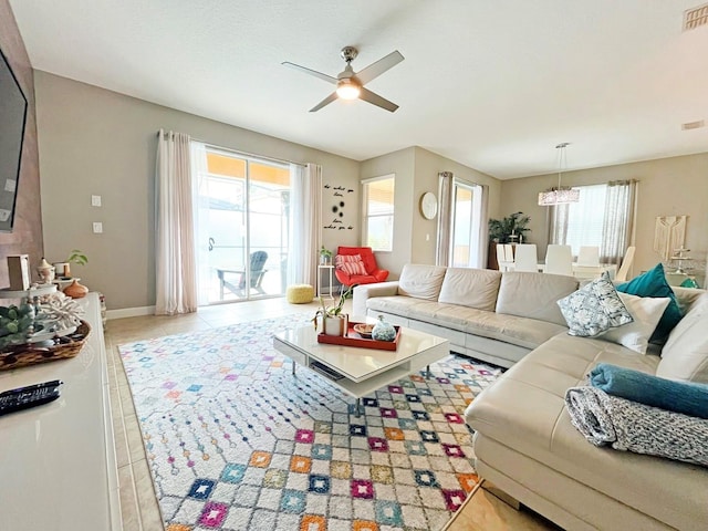 living room with ceiling fan with notable chandelier