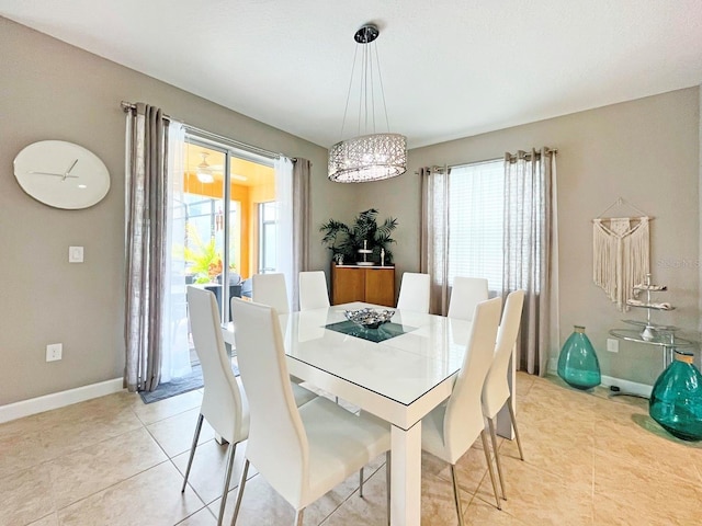 tiled dining room featuring a healthy amount of sunlight and a chandelier