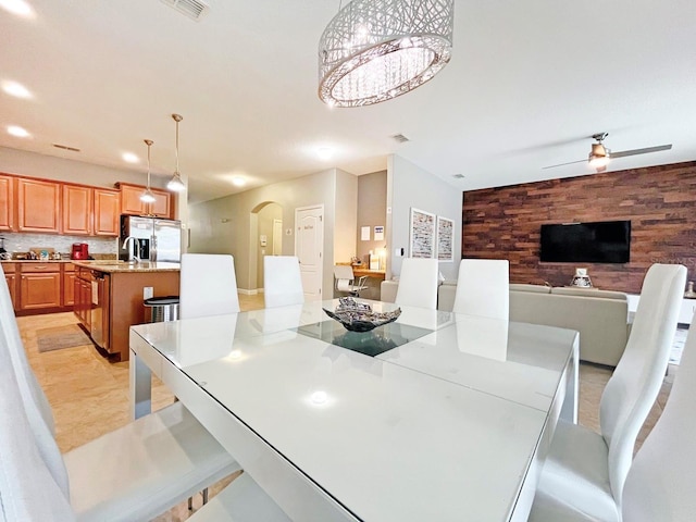 dining area featuring ceiling fan and wood walls