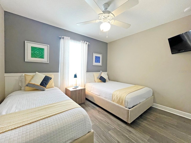 bedroom featuring wood-type flooring, a textured ceiling, and ceiling fan