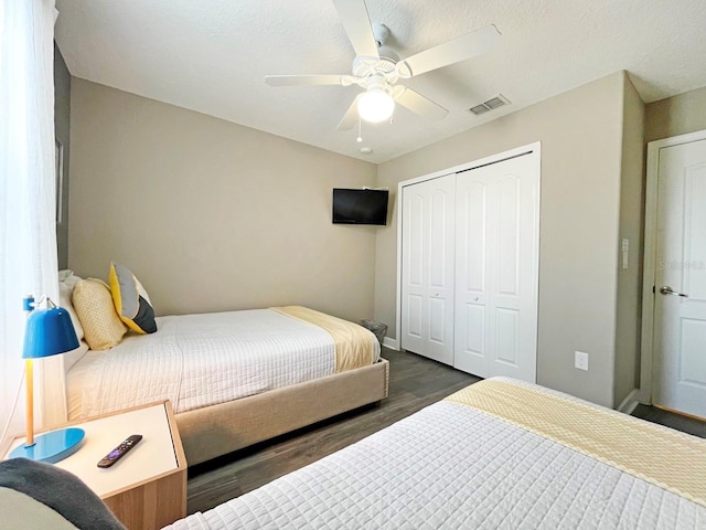 bedroom with ceiling fan, dark hardwood / wood-style flooring, and a closet