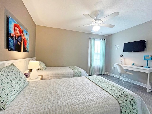 bedroom with ceiling fan, a textured ceiling, and hardwood / wood-style flooring