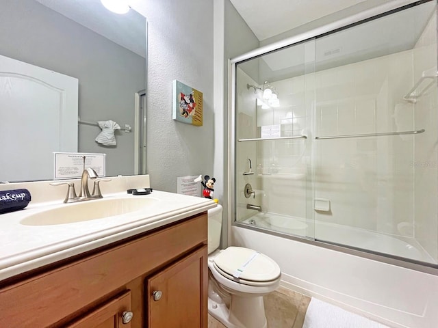 full bathroom featuring tile patterned flooring, vanity, toilet, and bath / shower combo with glass door