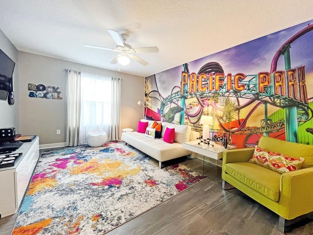 playroom featuring dark hardwood / wood-style floors, ceiling fan, and a textured ceiling