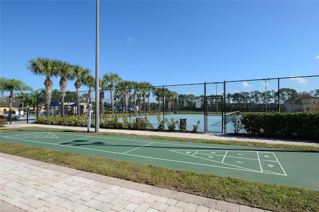 view of community with a water view and tennis court