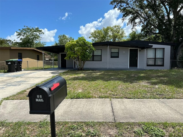 ranch-style house with a front yard and a carport