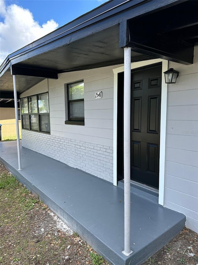 view of exterior entry with a porch