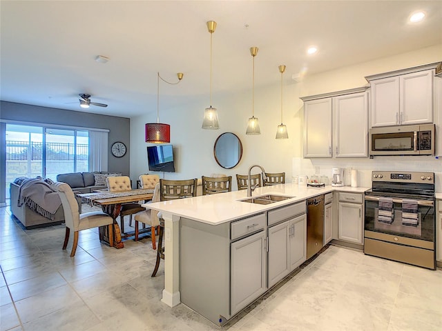 kitchen featuring gray cabinetry, kitchen peninsula, sink, and appliances with stainless steel finishes