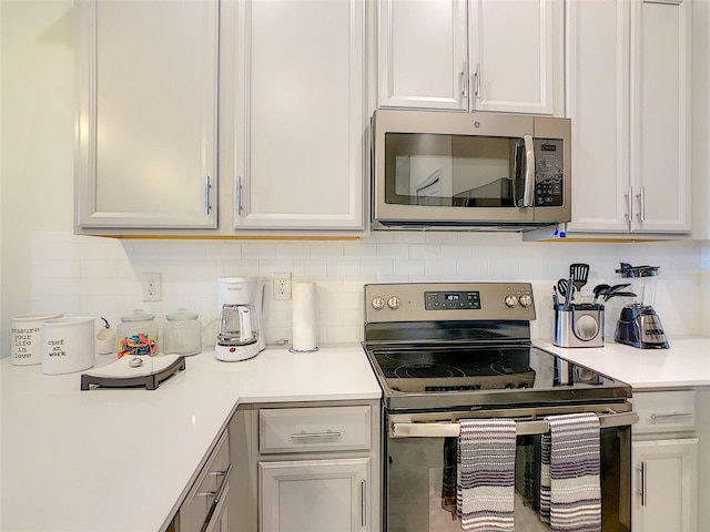 kitchen with appliances with stainless steel finishes and tasteful backsplash