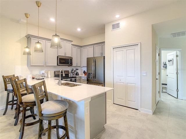 kitchen with stainless steel appliances, gray cabinets, pendant lighting, sink, and light tile floors