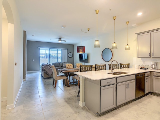 kitchen with kitchen peninsula, dishwasher, gray cabinets, sink, and pendant lighting