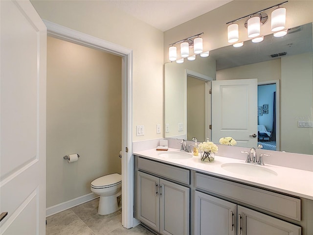 bathroom featuring dual vanity, tile floors, and toilet