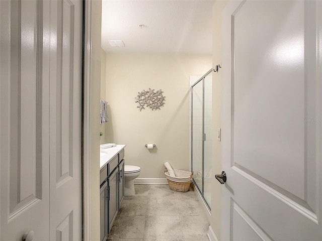 bathroom with a shower with door, tile flooring, toilet, and vanity