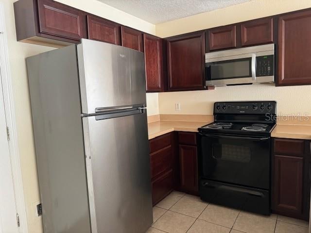 kitchen featuring light tile floors and appliances with stainless steel finishes