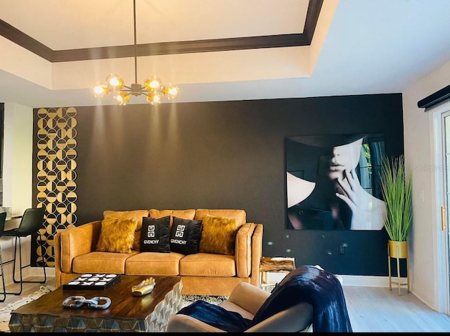 living room featuring an inviting chandelier, a raised ceiling, and hardwood / wood-style flooring