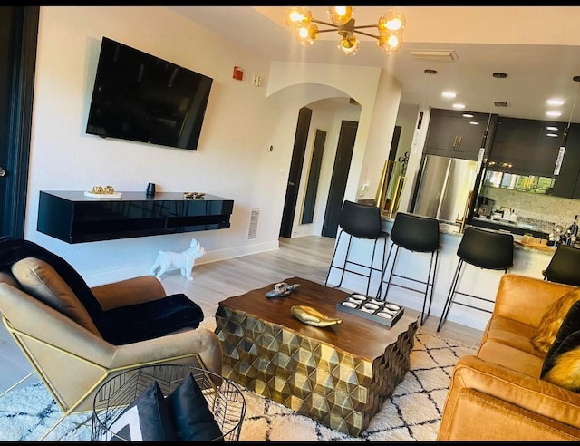 living room featuring an inviting chandelier and light hardwood / wood-style flooring