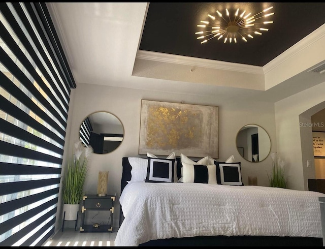 bedroom with ornamental molding and a tray ceiling