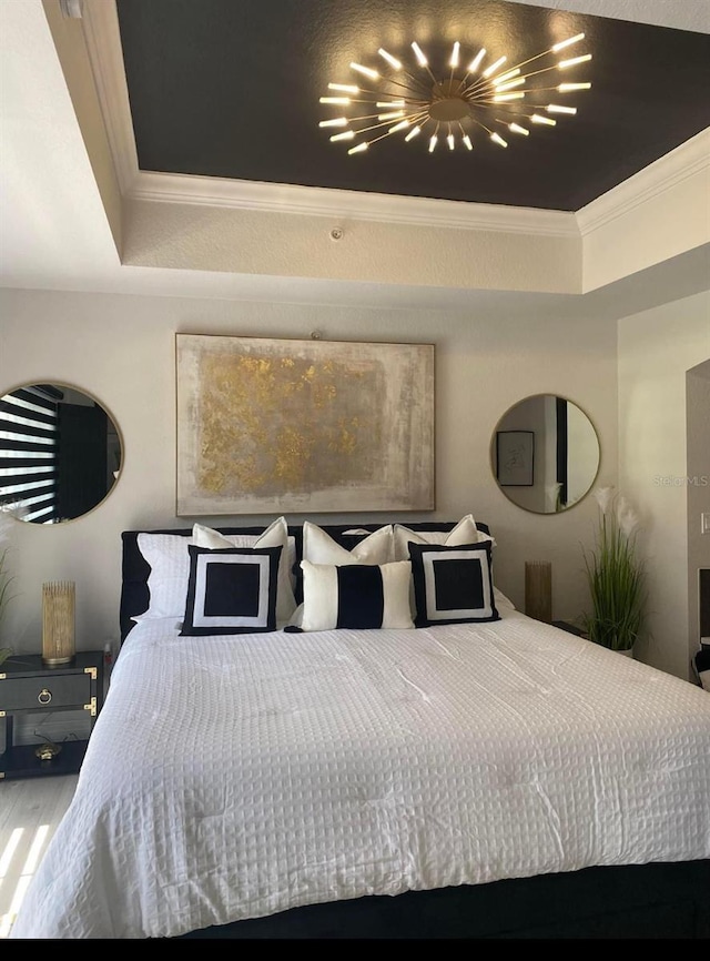 bedroom with ornamental molding and a tray ceiling