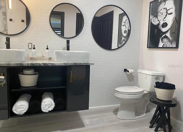 bathroom with hardwood / wood-style floors, vanity, and toilet