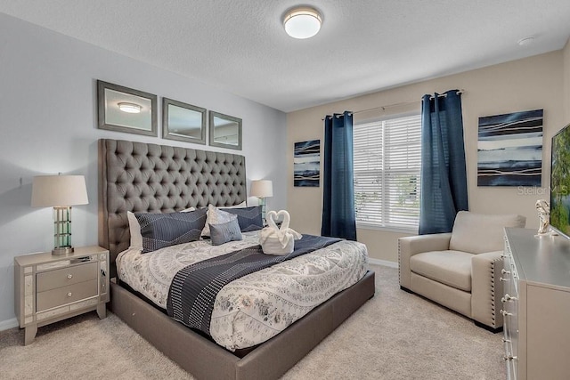 bedroom with a textured ceiling and light carpet