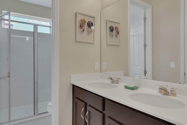 bathroom featuring vanity, toilet, and a shower with shower door