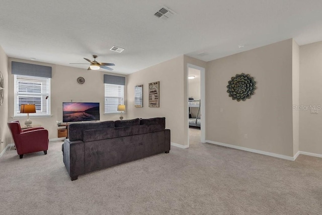 carpeted living room with ceiling fan