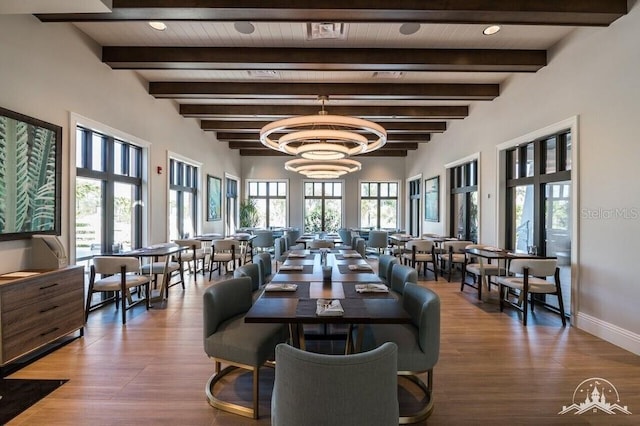 dining area featuring beam ceiling and an inviting chandelier