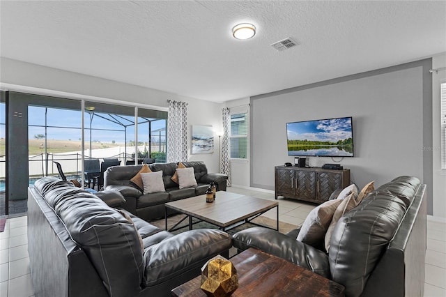 tiled living room featuring a textured ceiling