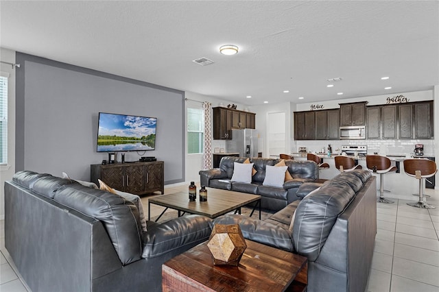 tiled living room featuring a textured ceiling