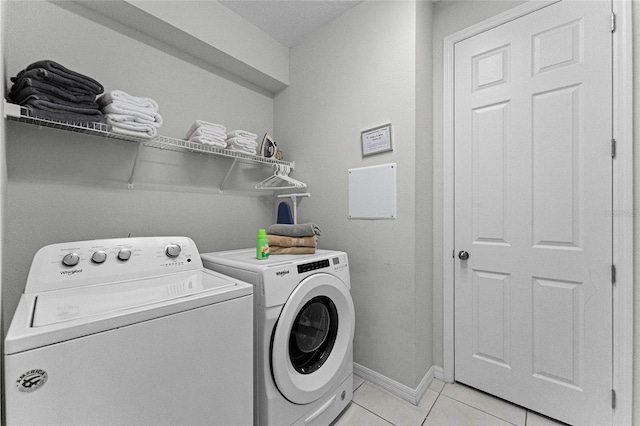 washroom with washing machine and dryer and light tile patterned floors