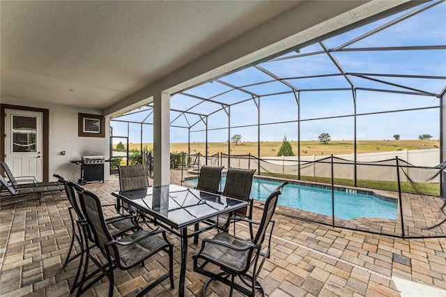 view of pool featuring a rural view, a patio, glass enclosure, and a grill