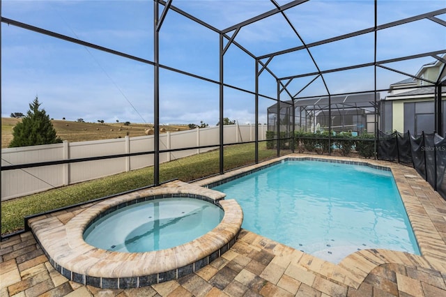 view of swimming pool featuring an in ground hot tub, a lanai, and a patio area