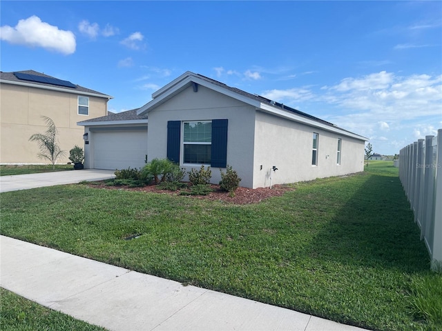 view of property exterior with a garage, a lawn, and solar panels