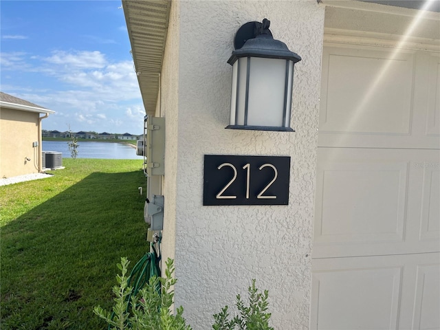 exterior details featuring central AC and a water view