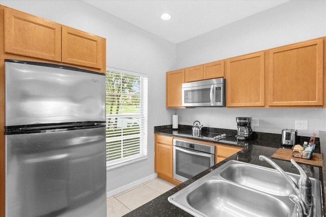 kitchen with sink, light tile patterned flooring, a healthy amount of sunlight, and appliances with stainless steel finishes