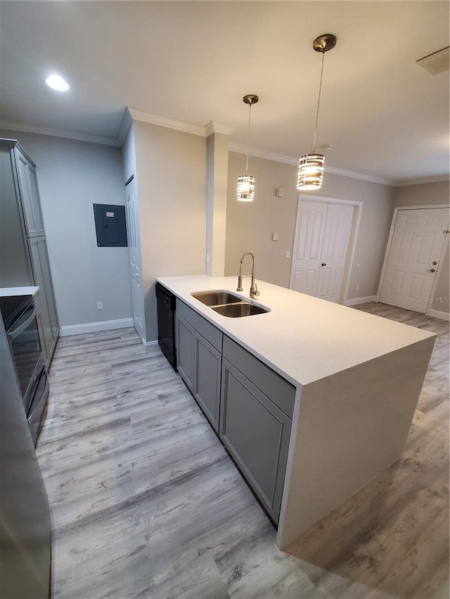 kitchen featuring electric range oven, pendant lighting, an island with sink, sink, and ornamental molding