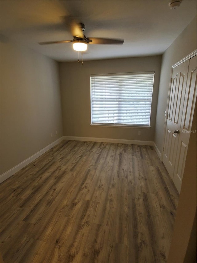 unfurnished room featuring dark hardwood / wood-style flooring and ceiling fan