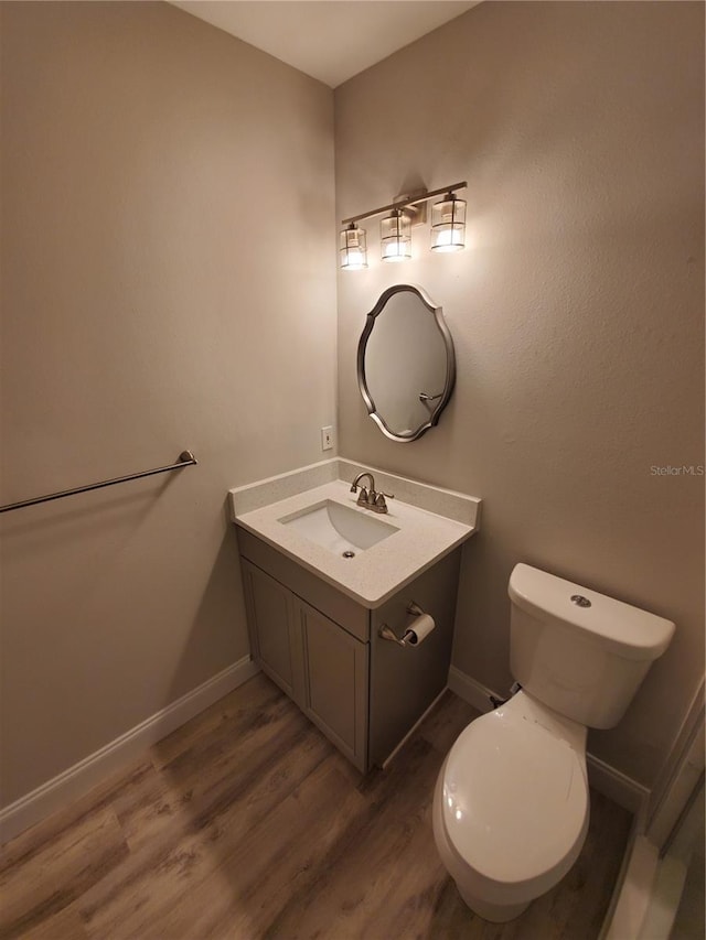 bathroom featuring vanity, hardwood / wood-style floors, and toilet