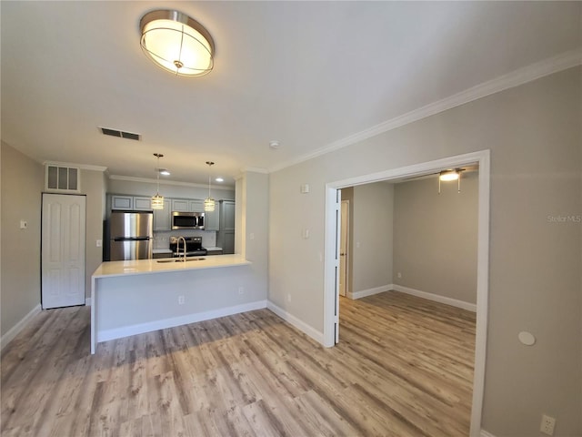 unfurnished living room with wood-type flooring, sink, and ornamental molding