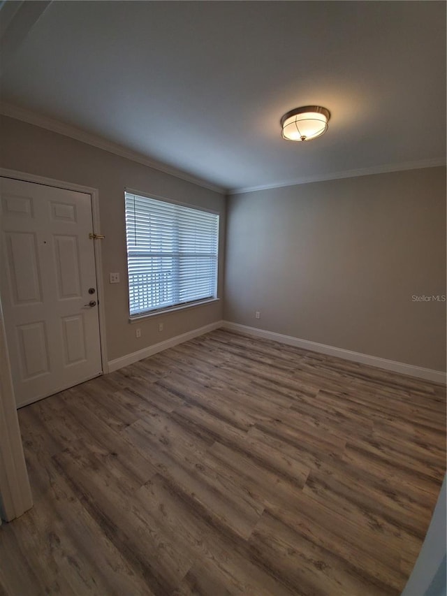 entrance foyer with ornamental molding and dark hardwood / wood-style floors