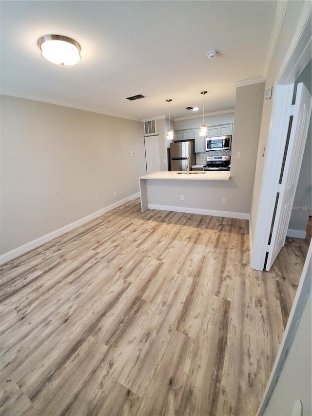 unfurnished living room featuring crown molding and light hardwood / wood-style flooring