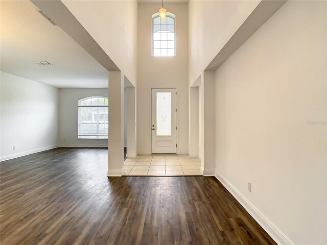 foyer with a healthy amount of sunlight, tile flooring, and a high ceiling