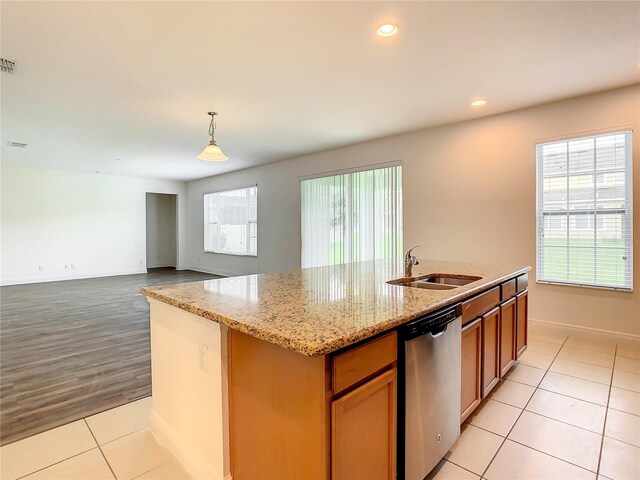 kitchen with light hardwood / wood-style flooring, a center island with sink, dishwasher, pendant lighting, and sink