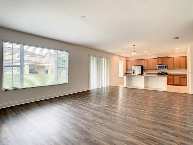 unfurnished living room featuring sink and light hardwood / wood-style flooring