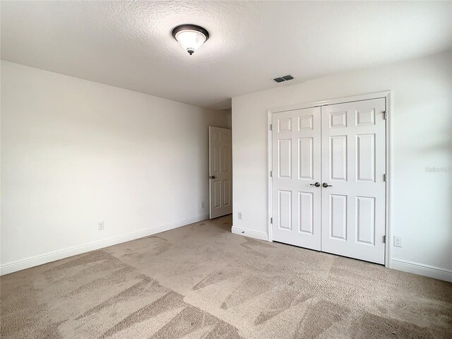 unfurnished bedroom with carpet flooring and a closet