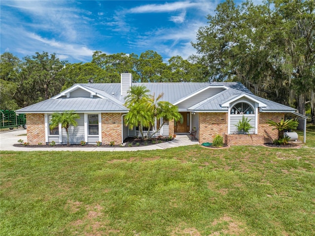 view of front of home featuring a standing seam roof, metal roof, and brick siding