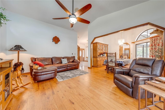 living area featuring ceiling fan with notable chandelier, high vaulted ceiling, and light wood-type flooring