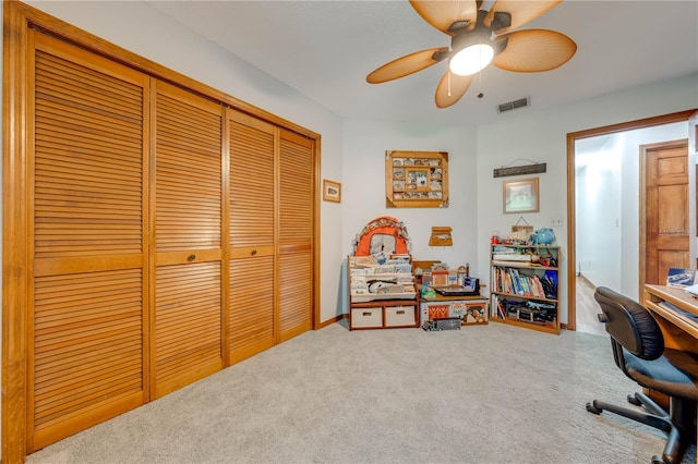 carpeted office with visible vents and ceiling fan