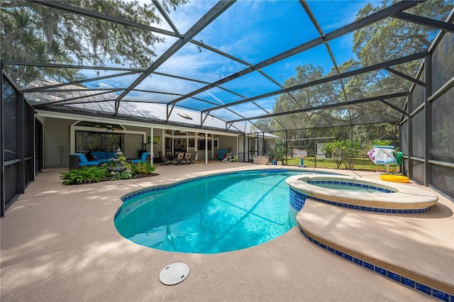 view of pool featuring outdoor lounge area, glass enclosure, ceiling fan, an in ground hot tub, and a patio area