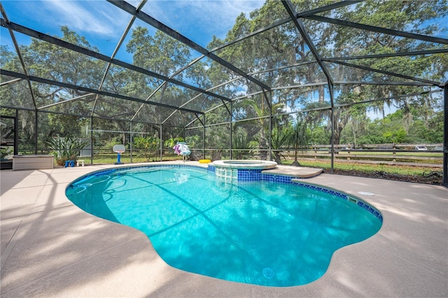 view of swimming pool featuring glass enclosure, a pool with connected hot tub, and a patio